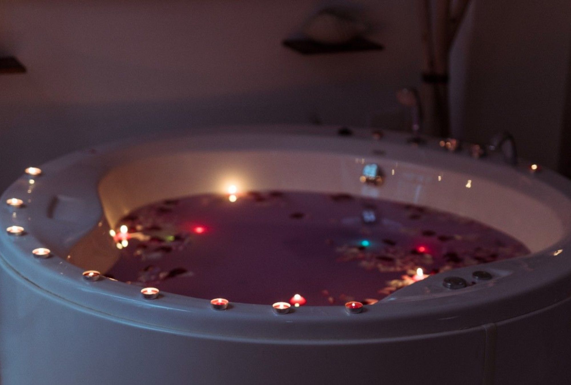 flower-petals-spa-tub-with-violet-water-burning-candles-edges (1)
